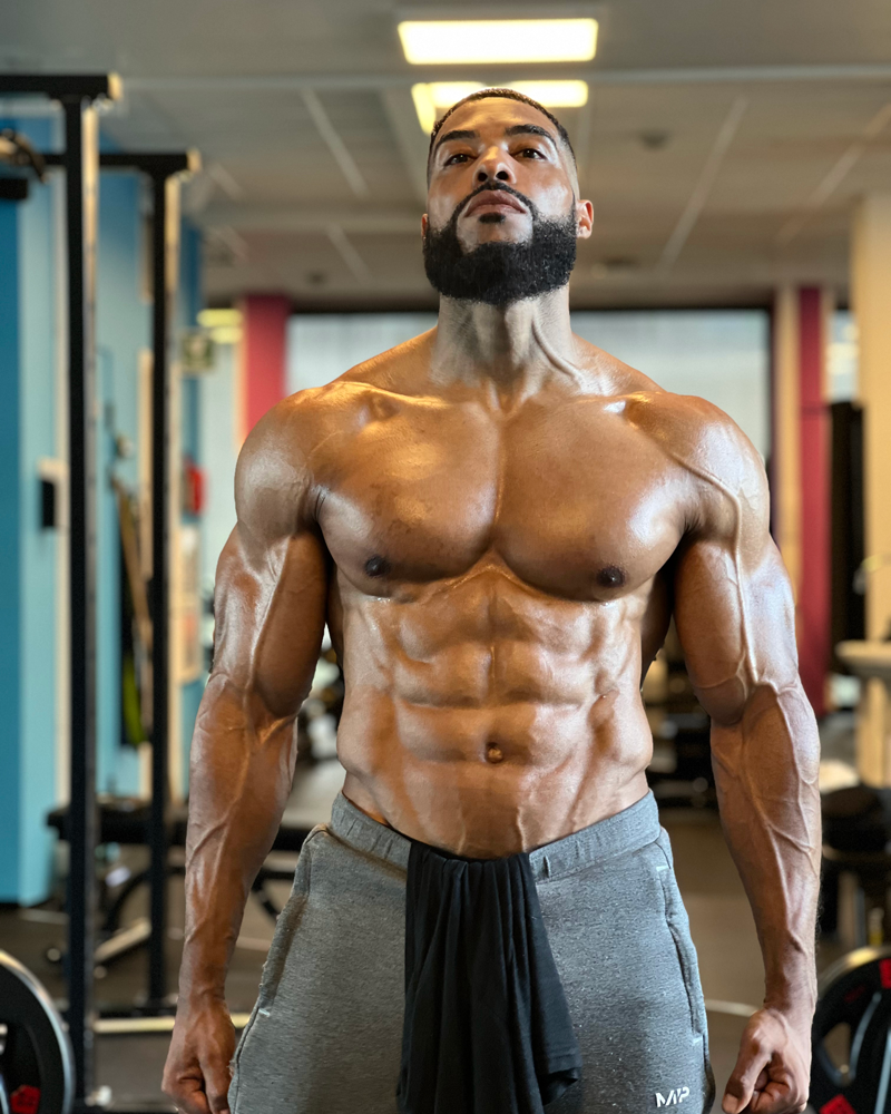 The coach is posing at the gym.